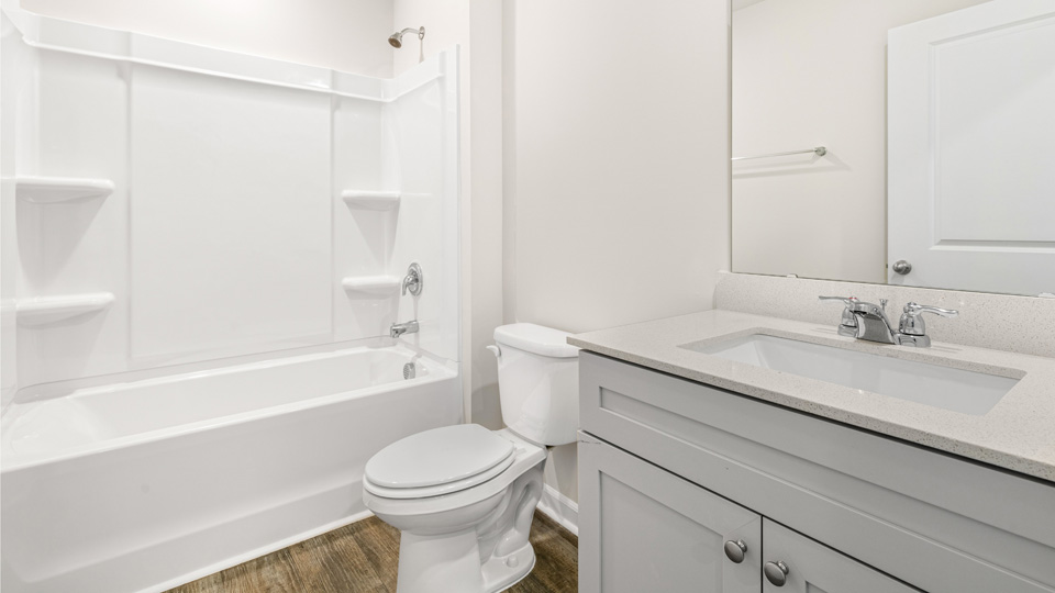 secondary bathroom with single vanity sink and shower-tub combi