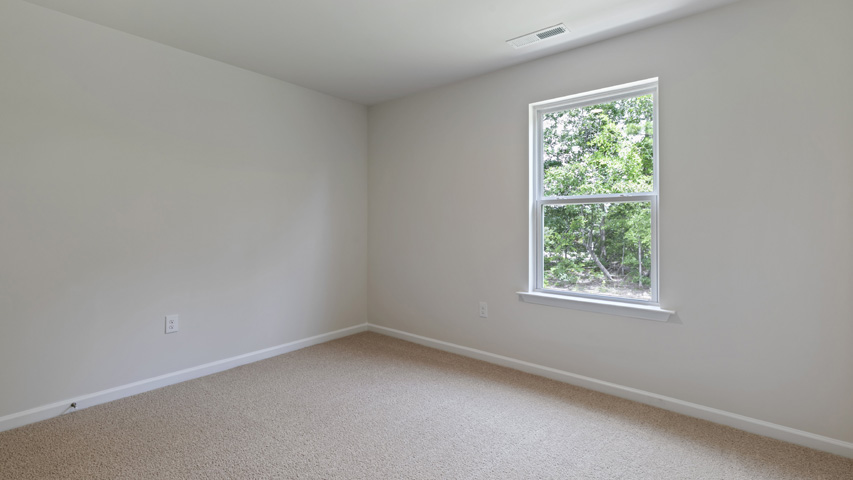secondary bedroom with window and carpeting