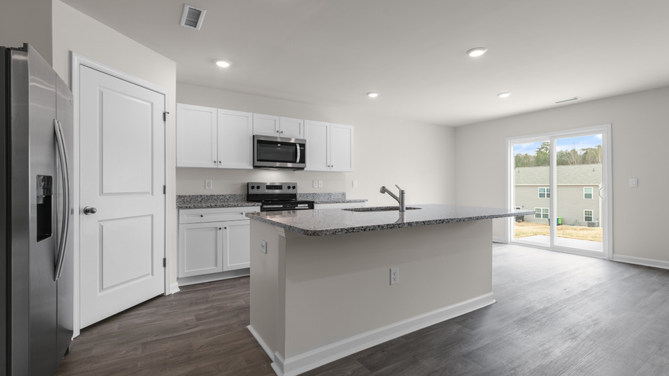 kitchen with stainless steel appliances, kitchen island, and sliding glass door to patio