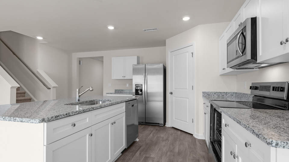 kitchen with stainless steel appliances, kitchen island, view of stairwell