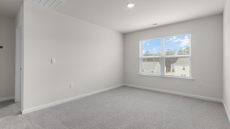 second story loft area with carpet and window