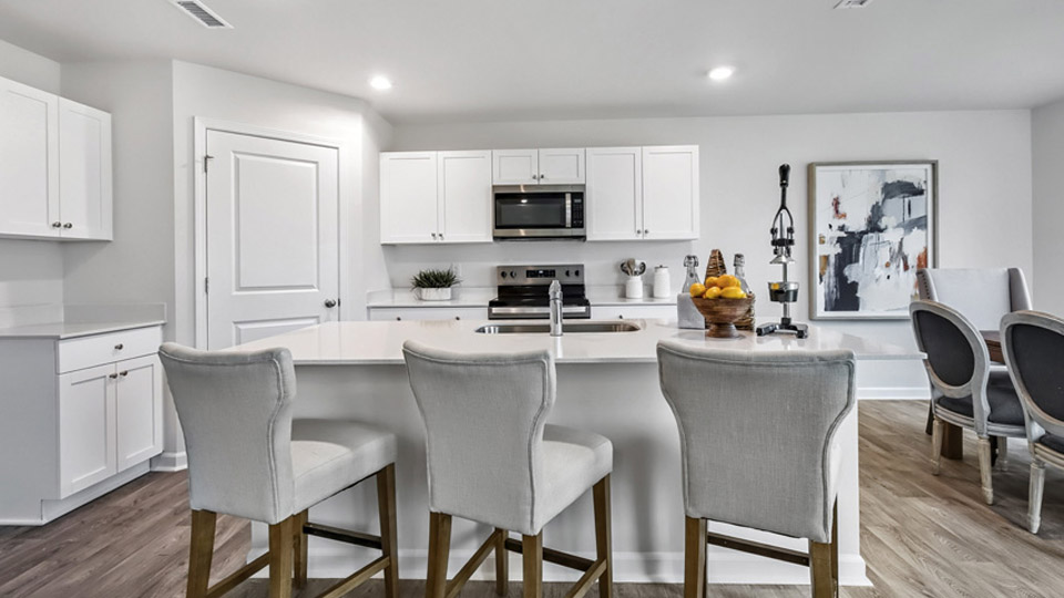 kitchen with quartz counters, kitchen island, pantry, stainless steel appliances