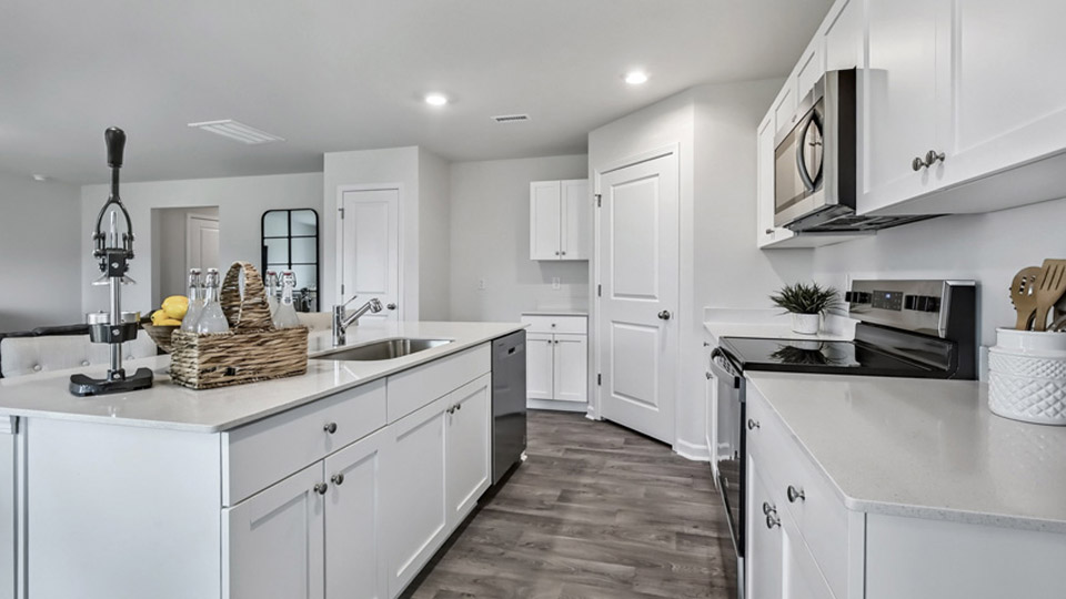 kitchen with quartz counters, kitchen island, pantry, stainless steel appliances