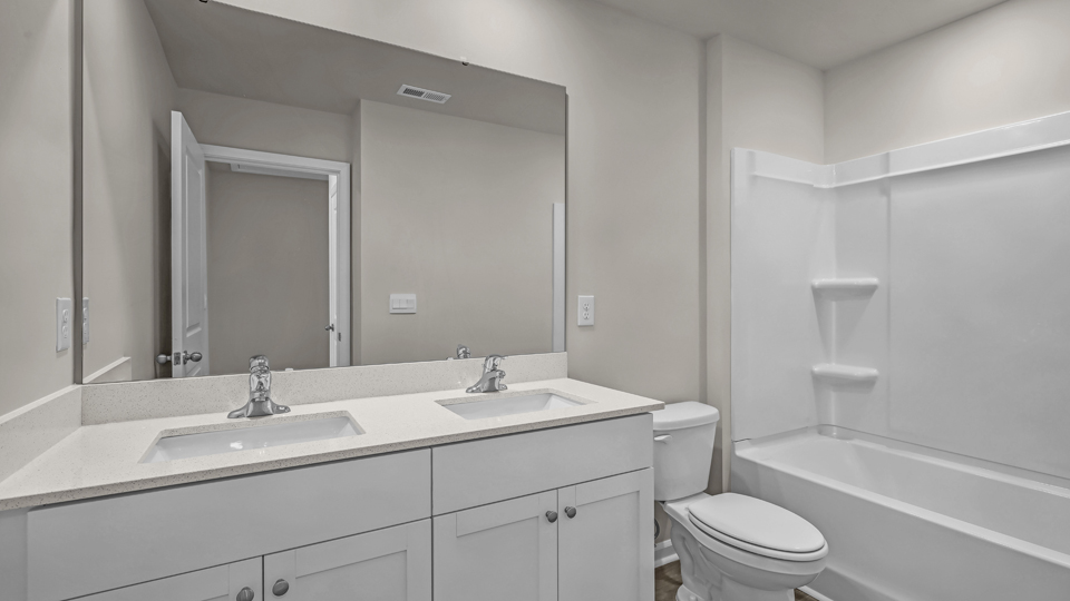 secondary bathroom with shower tub combo and double vanity sink