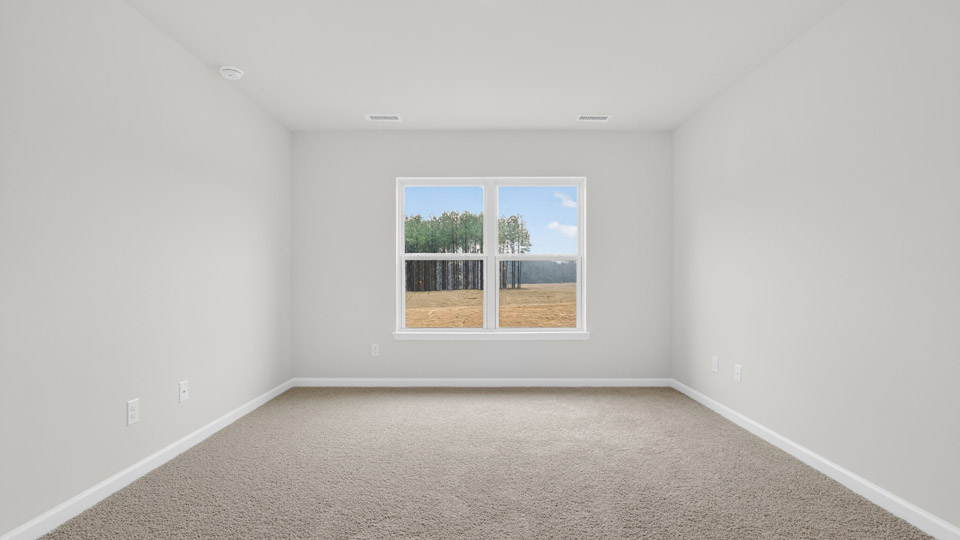 primary bedroom with two windows and carpeting, attached bath