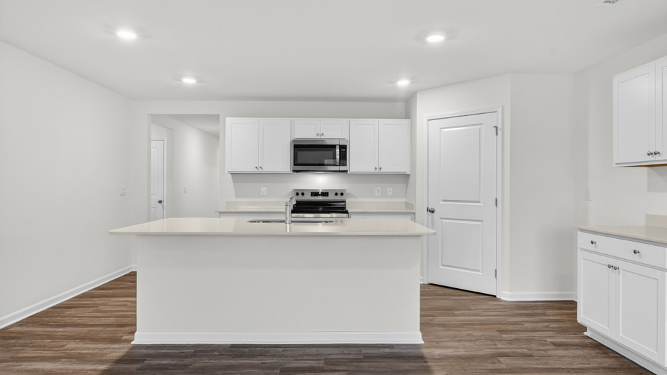kitchen with quartz counters, kitchen island, pantry, stainless steel appliances