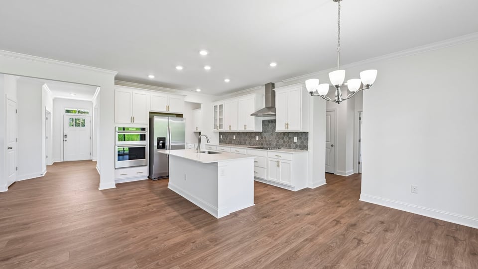 kitchen with white cabinets spacious island and quartz countertops