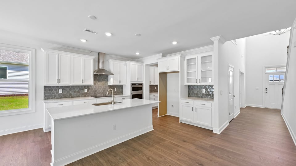kitchen with white cabinets quartz countertops and spacious island