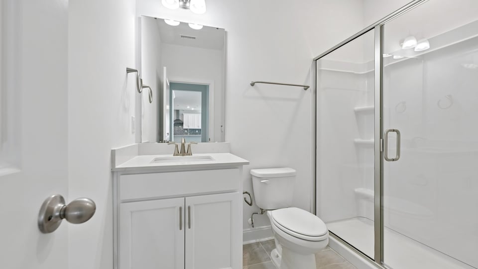 secondary bathroom with walking shower and quartz countertops