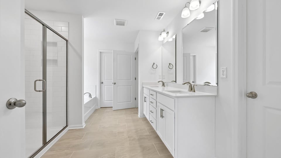 bathroom with dual vanity and walkin shower with glass doors