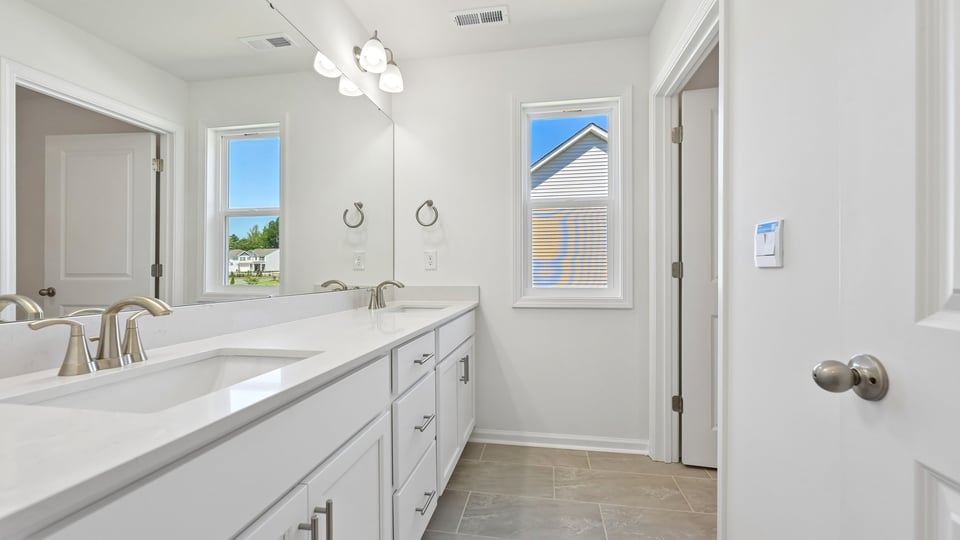 bathroom with dual vanity and quartz countertops