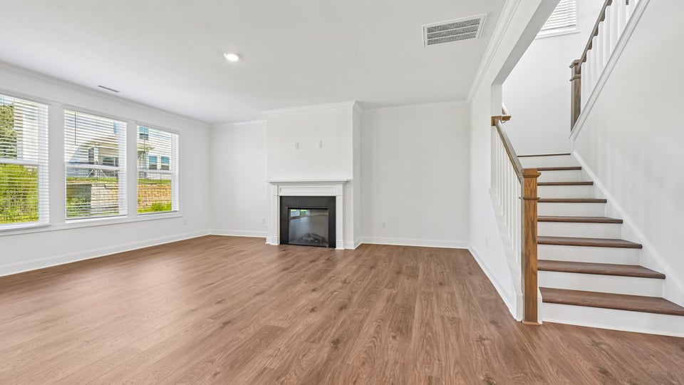 open living room with fireplace and staircase leading upstairs