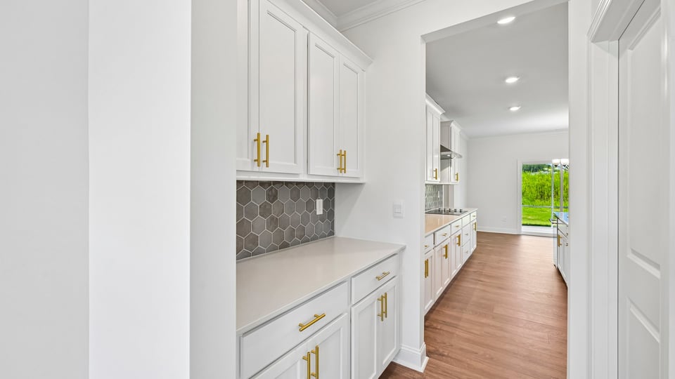 butlers pantry with tile backsplash and quartz countertops