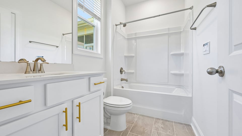 bathroom with white cabinets quartz countertops and tub shower combo