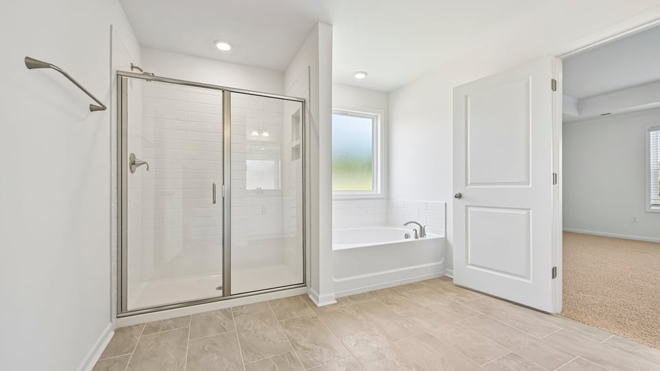 primary bathroom with walkin glass doors shower and separate tub