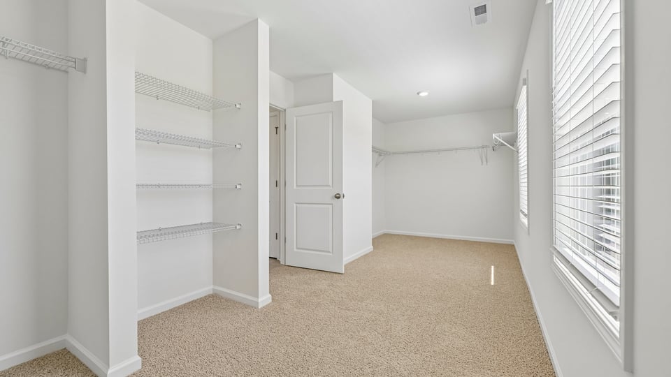 huge walkin closet with wire shelving and natural lighting
