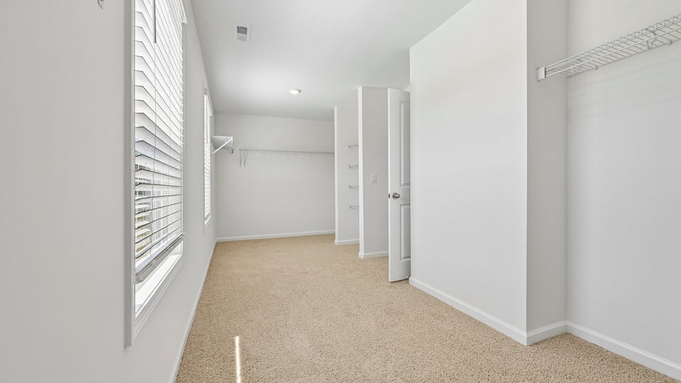 huge walkin closet with wire shelving and natural lighting