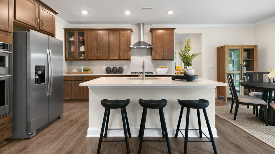 kitchen with quartz counters, kitchen island, pantry, stainless steel appliances