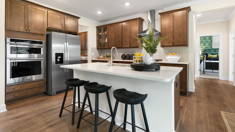 kitchen with quartz counters, kitchen island, pantry, stainless steel appliances