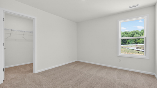 bedroom with carpet flooring and walkin closet