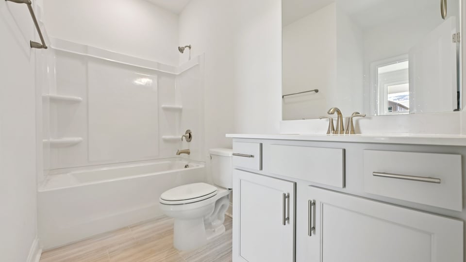 bathroom with gray cabinets and quartz countertops