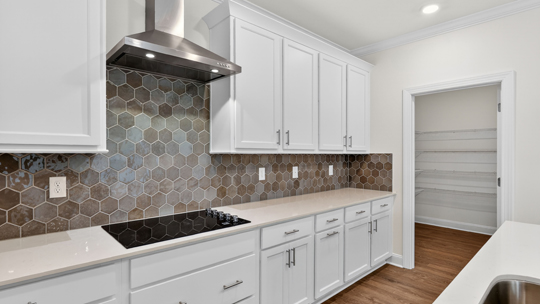 kitchen with quartz counters, kitchen island, pantry, stainless steel appliances