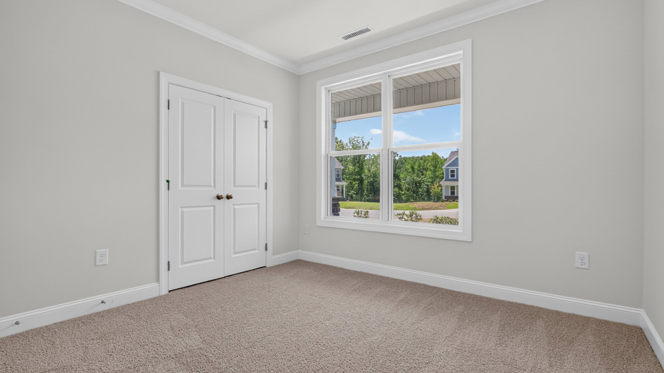 secondary bedroom with window and closet, carpeting