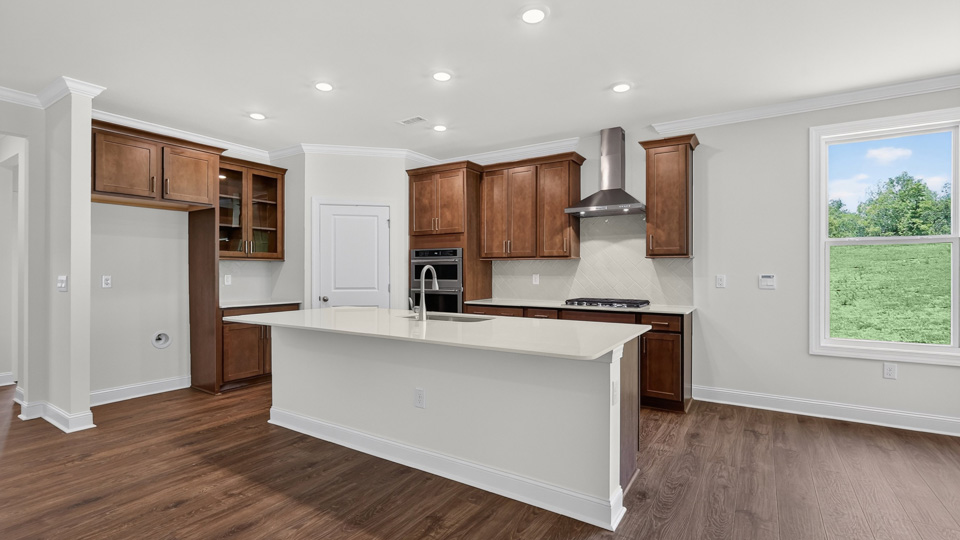 kitchen with quartz counters, kitchen island, pantry, stainless steel appliances