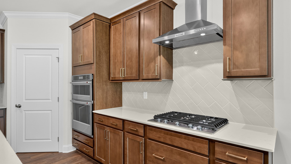 kitchen with quartz counters, kitchen island, pantry, stainless steel appliances