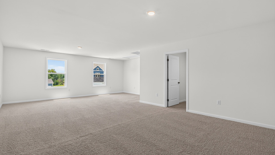 upstairs loft area with large windows and carpeting