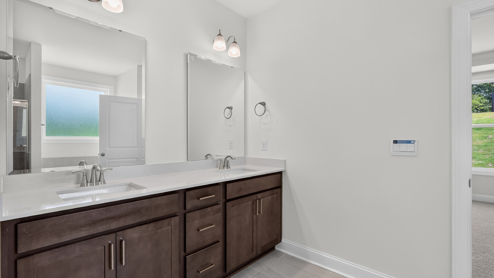 primary bathroom with walk in shower, bathtub, and dual vanity sinks