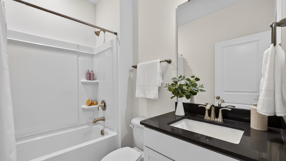bathroom with tub shower combo and quartz countertops