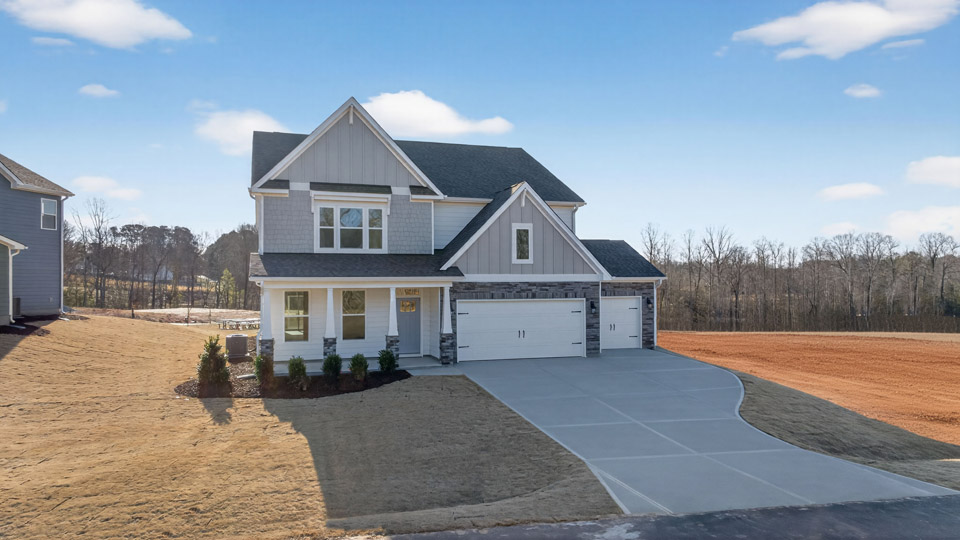 Two story home with white colored siding with a two car garage