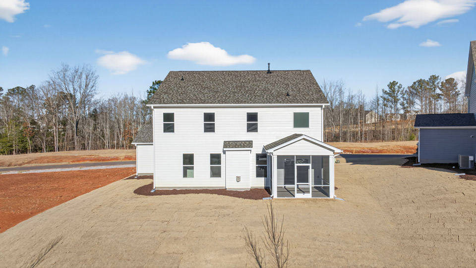 Two story home with white colored siding with a back patio