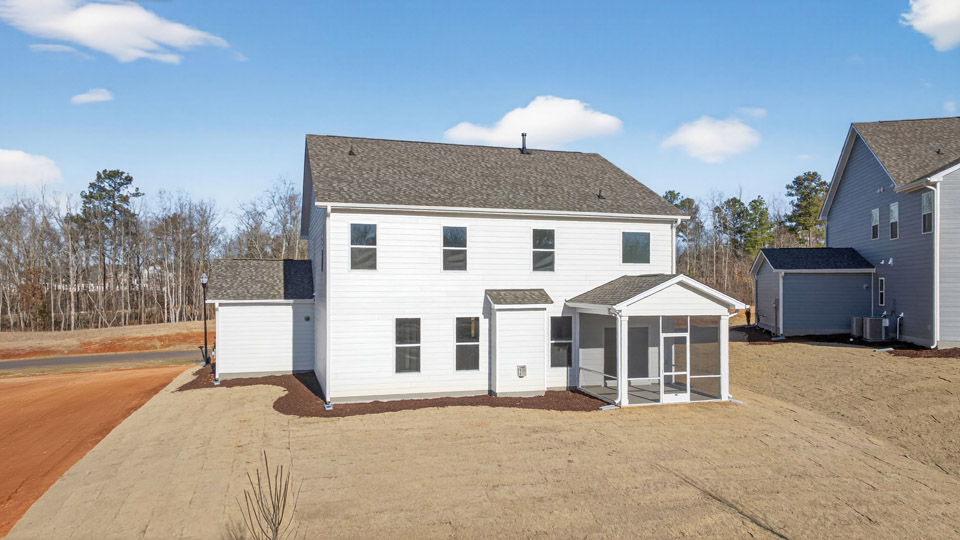 Two story home with white colored siding with a back patio