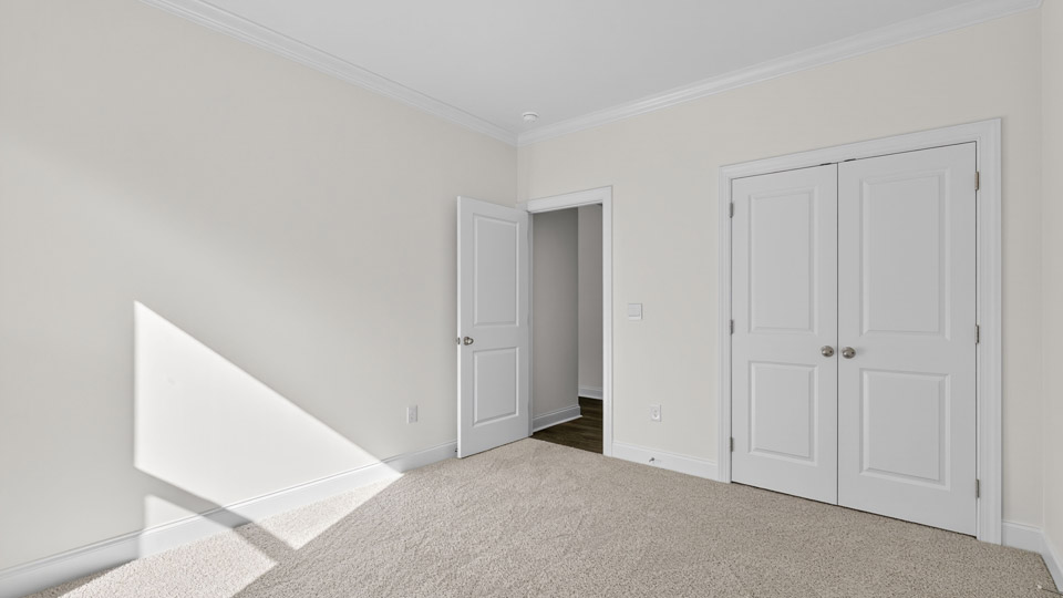 secondary bedroom with window and closet, carpeting