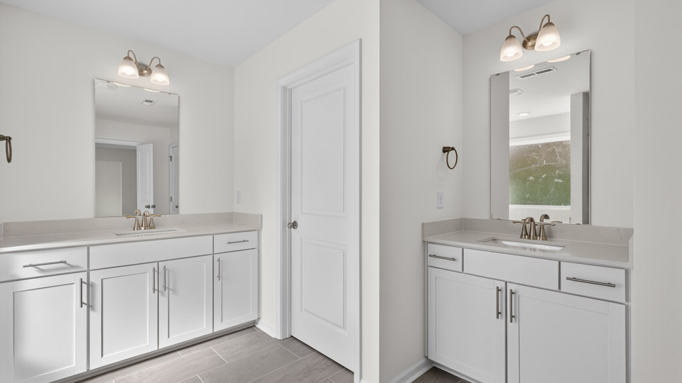 primary bathroom with walk in shower and dual vanity sinks