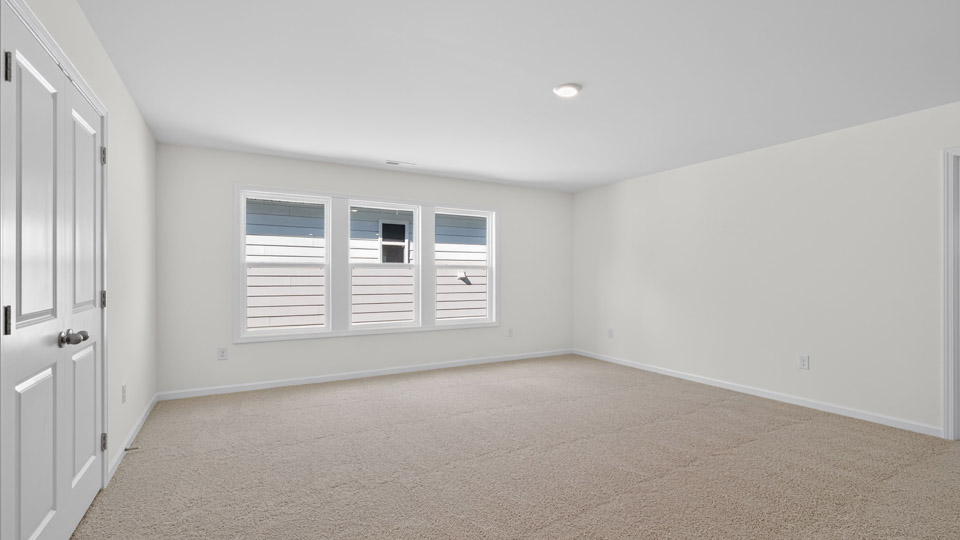 upstairs loft area with large windows and carpeting
