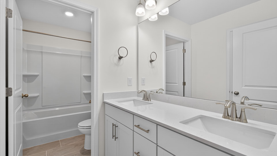 primary bathroom with walk in shower and dual vanity sinks