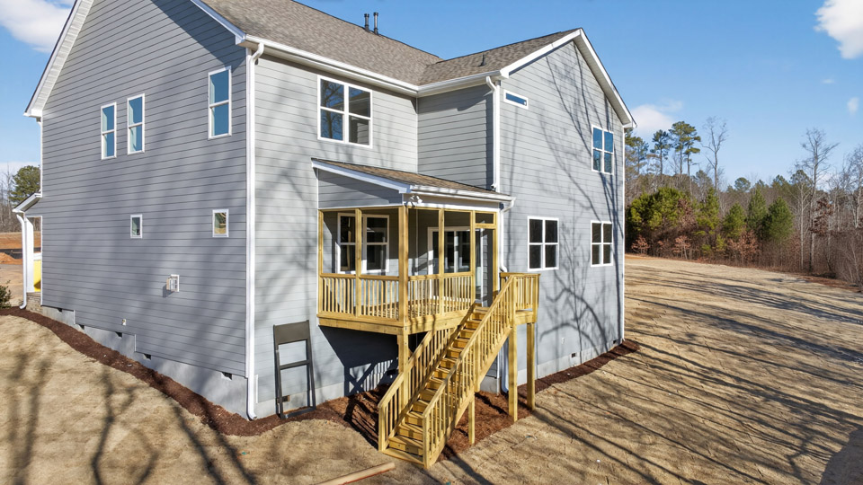 Two story home with blue colored siding with a back patio