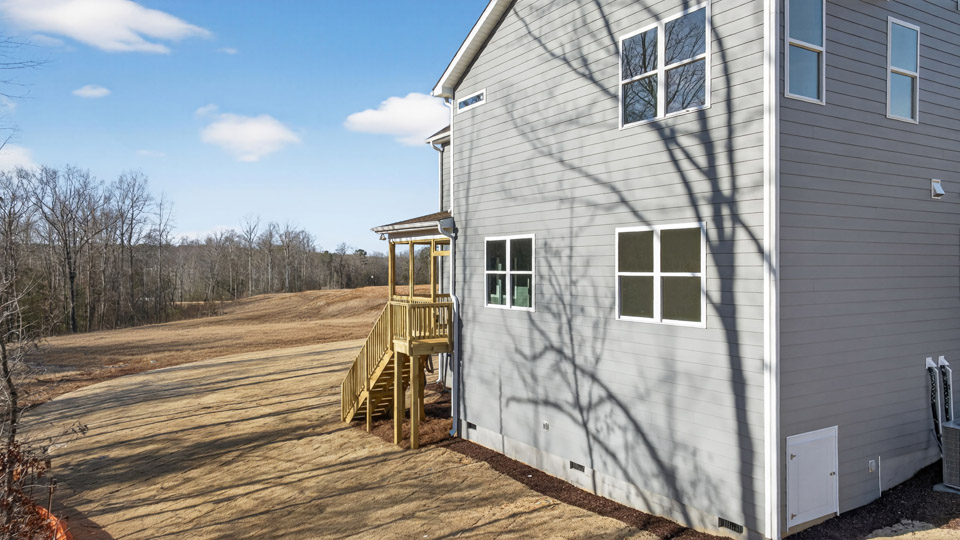 Two story home with blue colored siding with a back patio