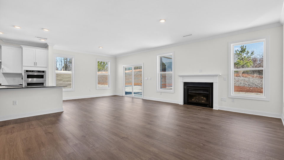 open concept living room with fireplace overlooked by kitchen