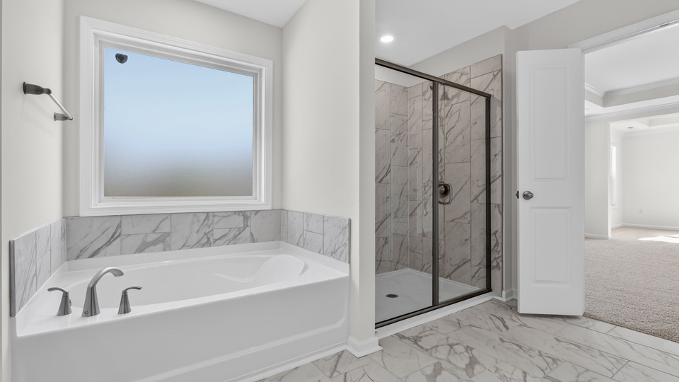 primary bathroom with separate tub and walkin shower