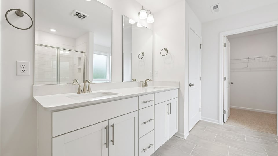 primary bathroom with dual vanity and walkin closet