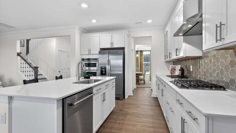 kitchen with quartz counters, kitchen island, pantry, stainless steel appliances