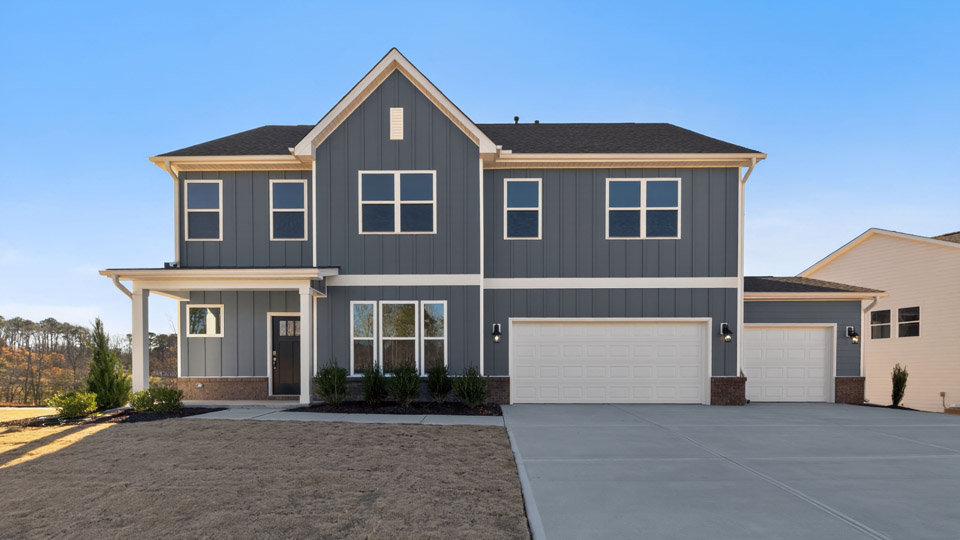 Two story home with gray siding and a three-car garage.