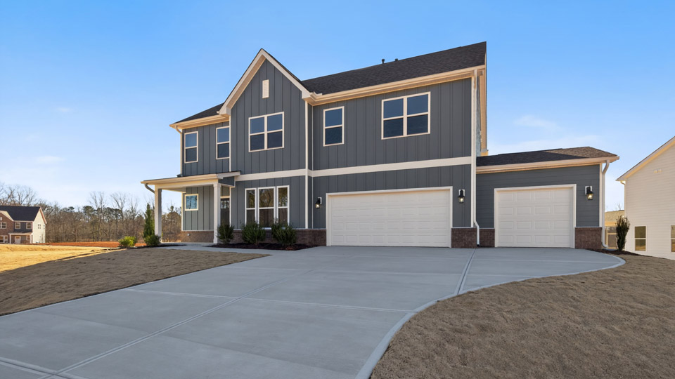 Two story home with gray siding and a three-car garage.