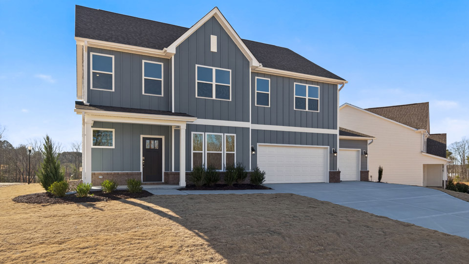 Two story home with gray siding and a three-car garage.