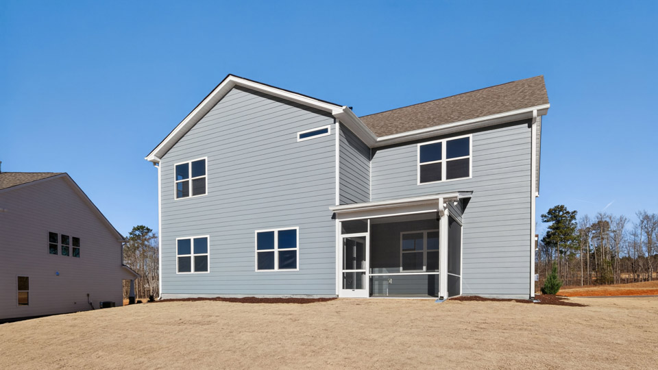 Two story home with gray siding and a covered back patio.