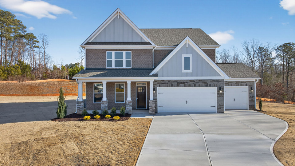 Two story home with blue colored siding with a three car garage